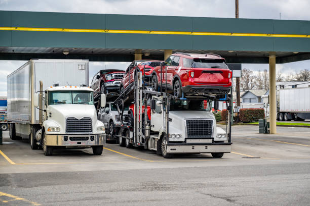 Industrial grade big rigs long hauler semi trucks with extended cabs for truck driver comfort rest standing in row with semi trailers on the marked spots on truck stop parking lot taking break