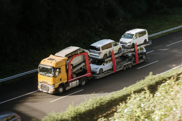 A large semi truck carrying cars and vans